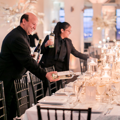 photo: waiters pouring wine at elegant table prior to event