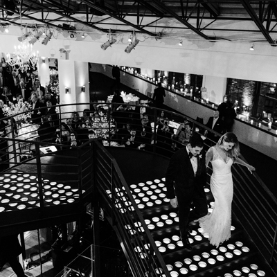 photo: bride and groom walking down stairs for their entrance