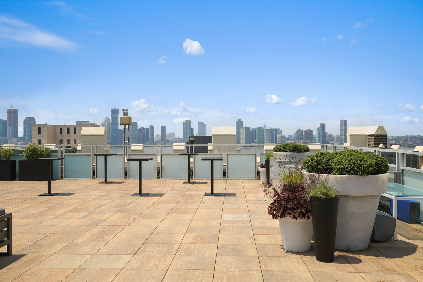 photo: rooftop cocktail space with tables and manhattan views